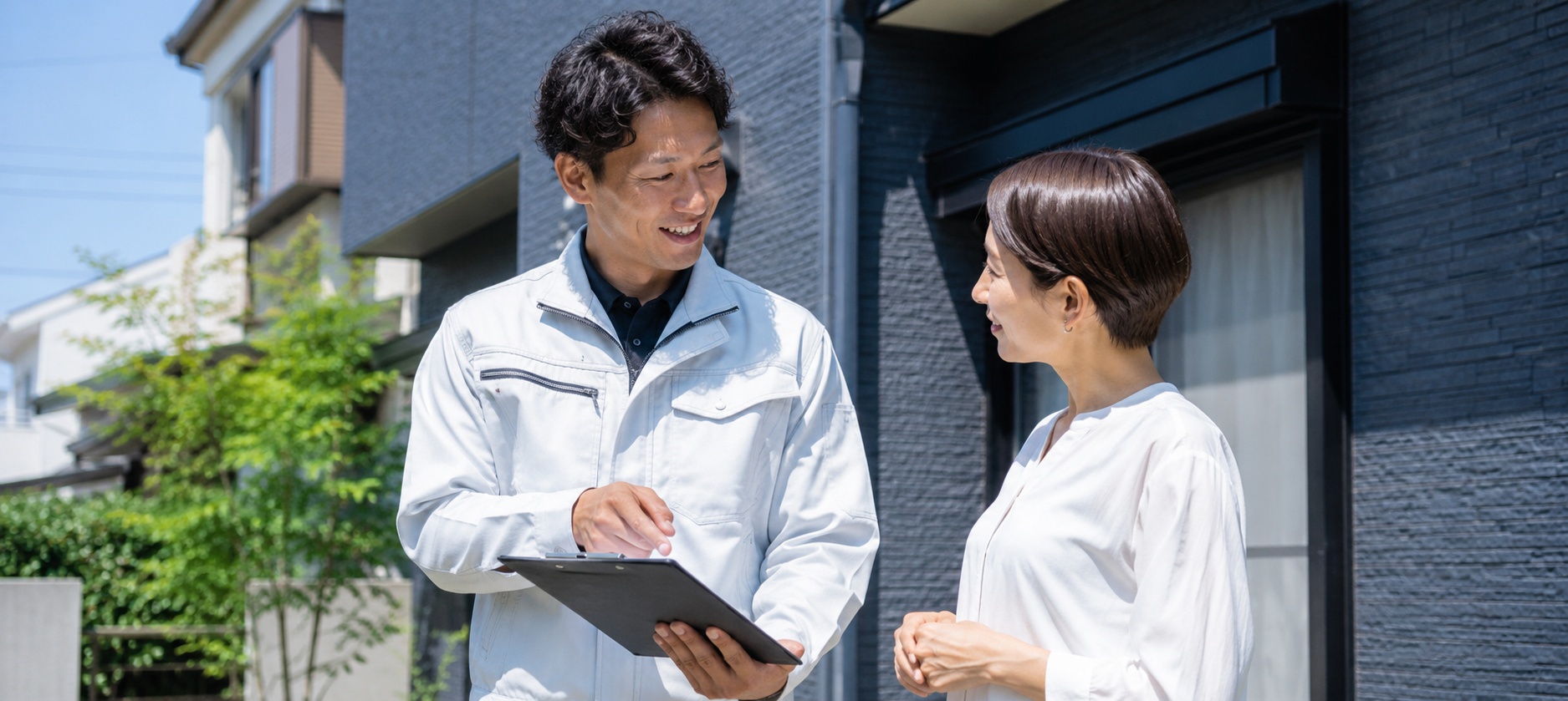夏に外壁塗装前の住宅点検をしている様子